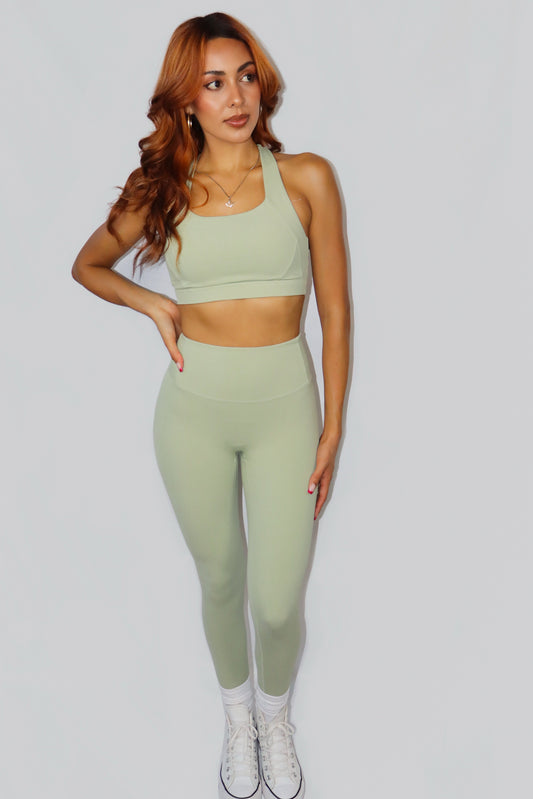 Woman wearing a green athletic outfit on a white background