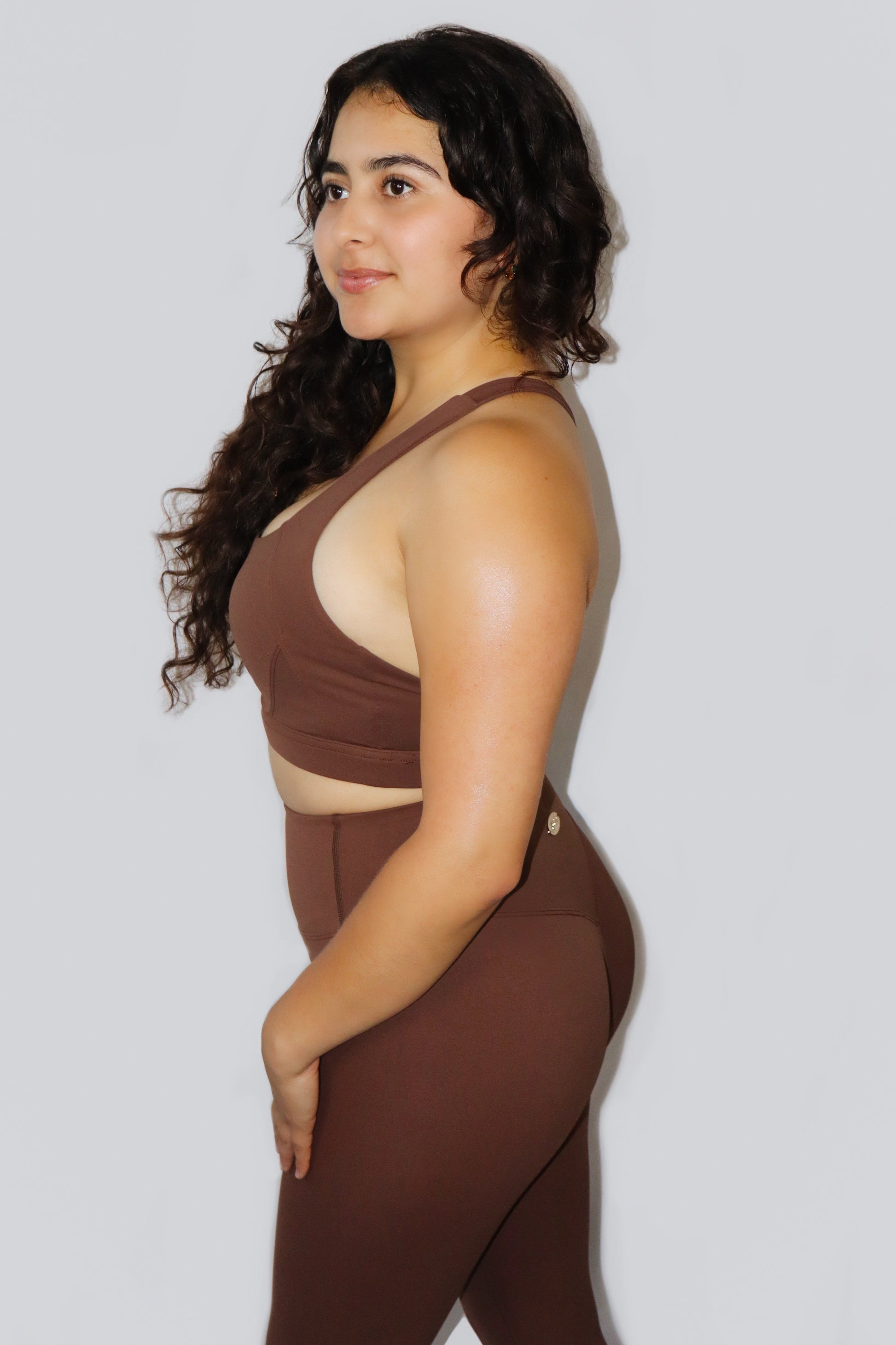 Woman wearing a brown outfit against a plain background